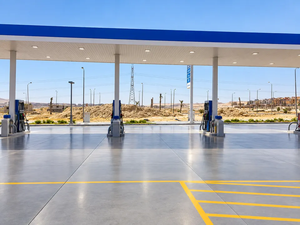 Grey forecourt/service-station floor under blue canopy