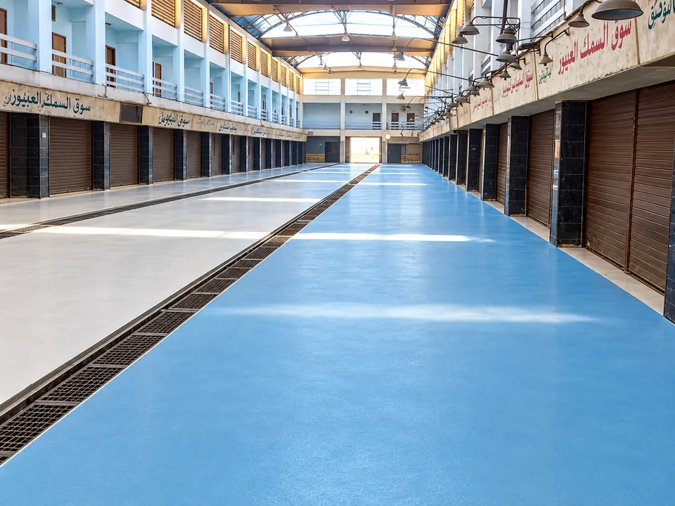 Blue floor in market/arcade corridor with drainage