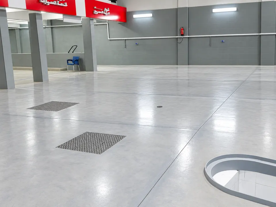 Grey clean service-bay floor with drainage