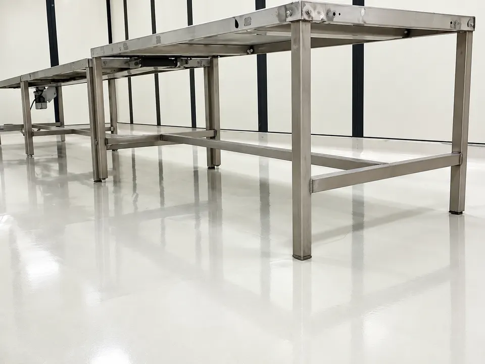 Light grey/white seamless floor around stainless worktable